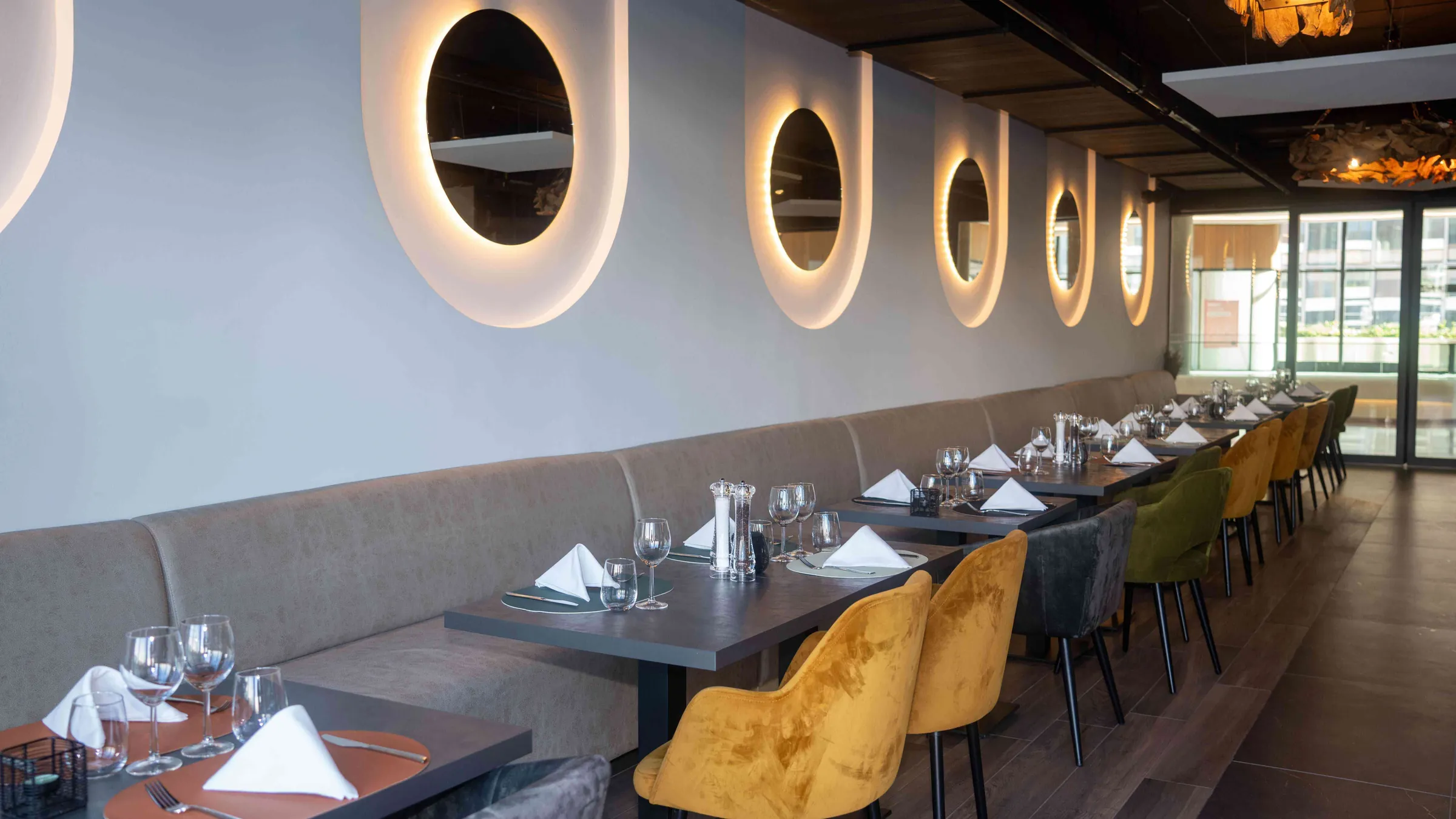 The long banquette under the round mirrors